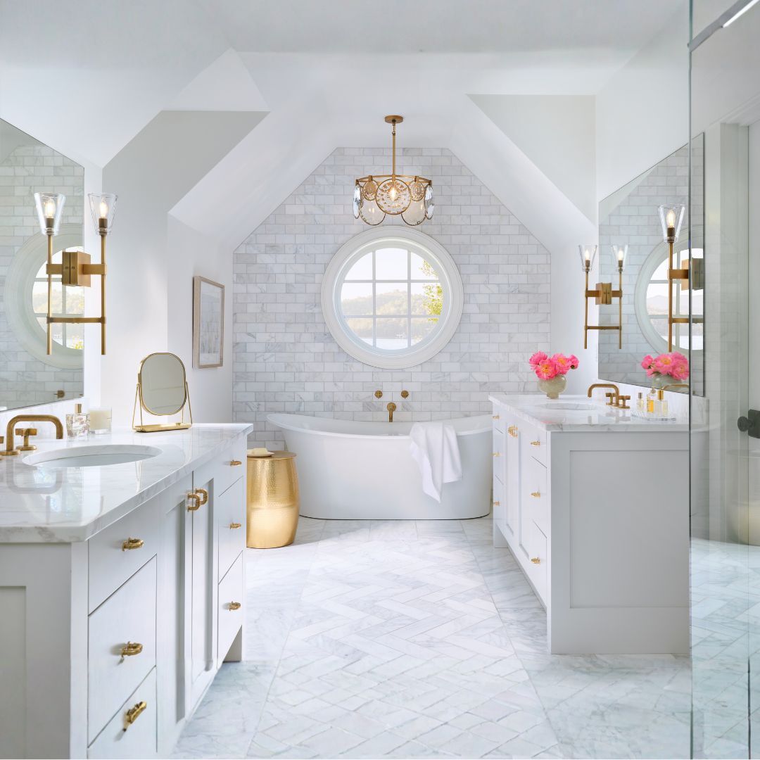 The focal points are the coordinated gold-finished light fixtures, including two elegant wall-mounted sconces with clear glass shades and a central ornate chandelier with decorative glass panels and a circular frame.