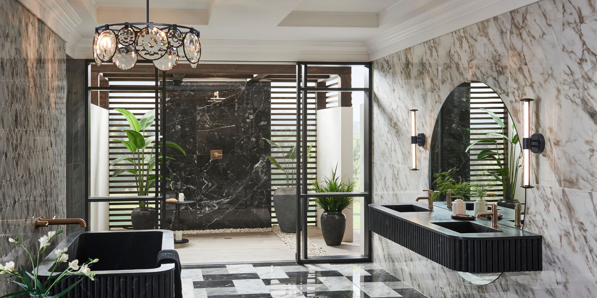 high-end lighting fixtures, featuring a large circular chandelier with a black frame and decorative crystal-like glass medallions, and two sleek, vertical cylinder-style black wall sconces with glowing white light panels flanking a round mirror.